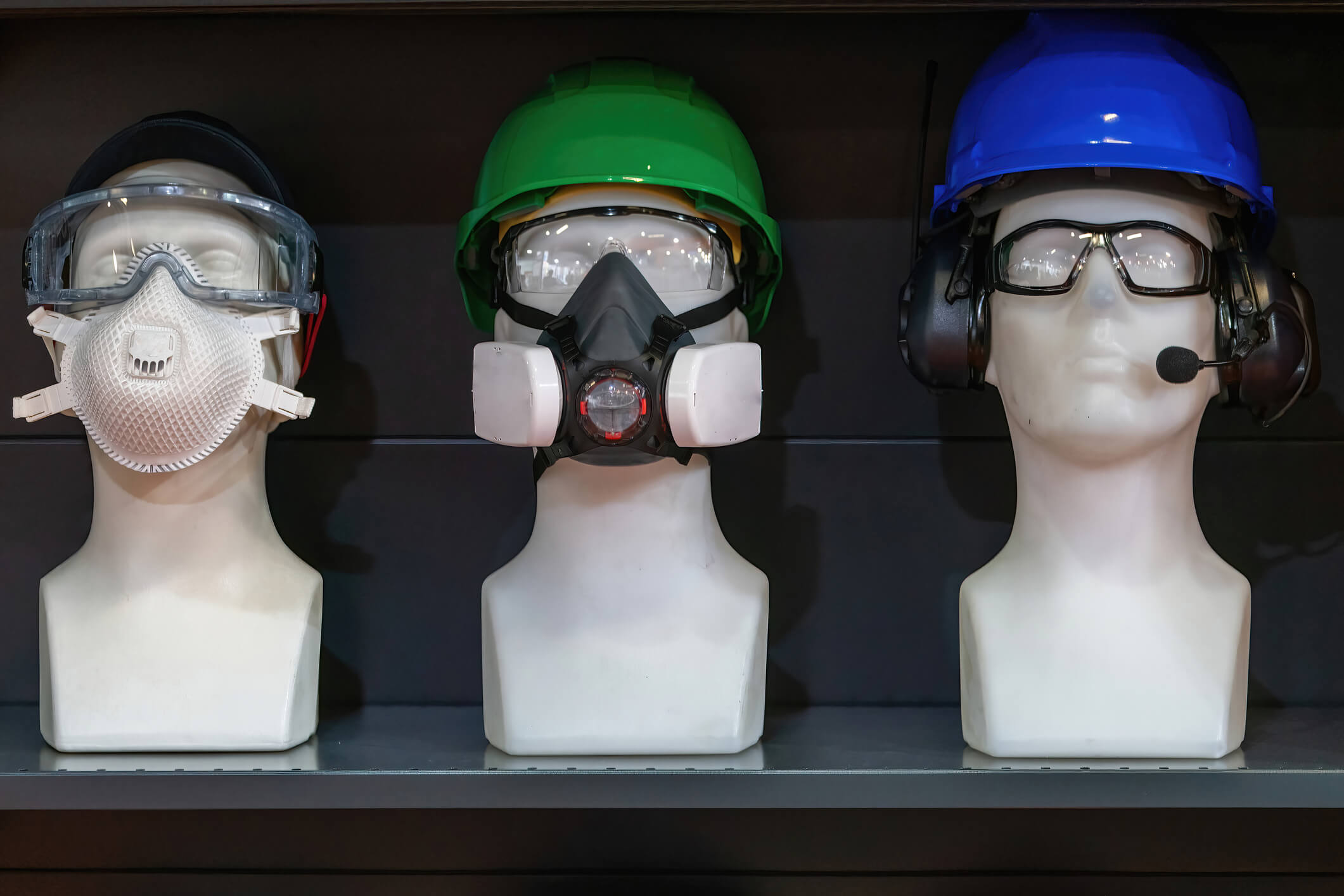 Three mannequins display safety helmets, goggles, and PPE masks, emphasizing personal protective equipment for safety.