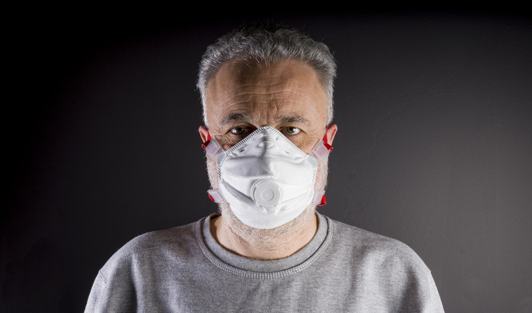 A man wearing a P3 mask stands against a dark background, emphasizing the mask's protective features.