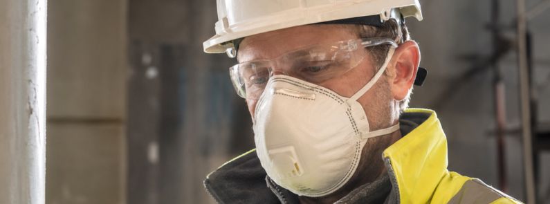 Industrial worker wearing a P3 mask, safety glasses and a hard hat on site